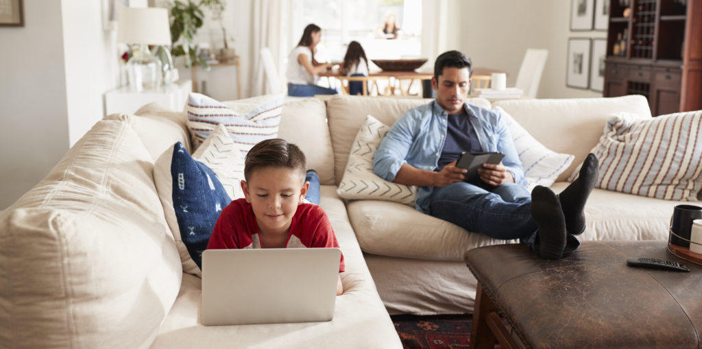 Family at home on laptops, tablets and mobile devices.